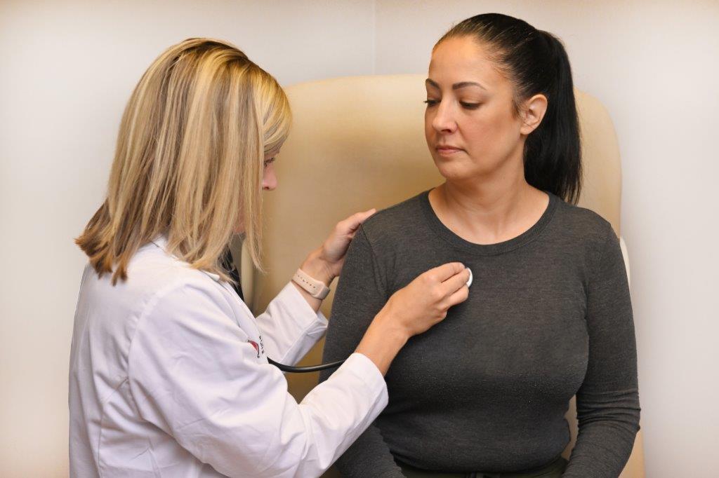 a doctor listening to her patient's heartbeat