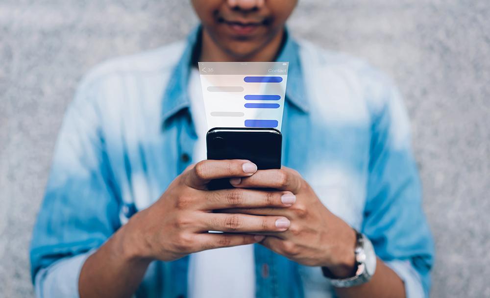 man using text messaging on his smart phone